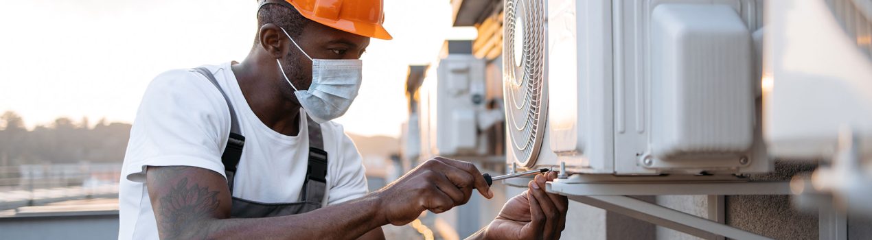 man-in-mask-kneeling-near-installed-air-conditione-2023-12-21-22-01-44-utc